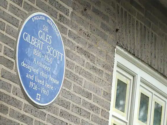 Blue plaque commemorating Sir Giles Gilbert Scott, architect, at his former residence, highlighting heritage significance and historical context.