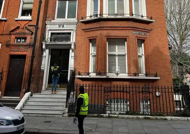 Edwardian property restoration with workers in high-visibility jackets at entrance, showcasing architectural features and meticulous attention to detail.