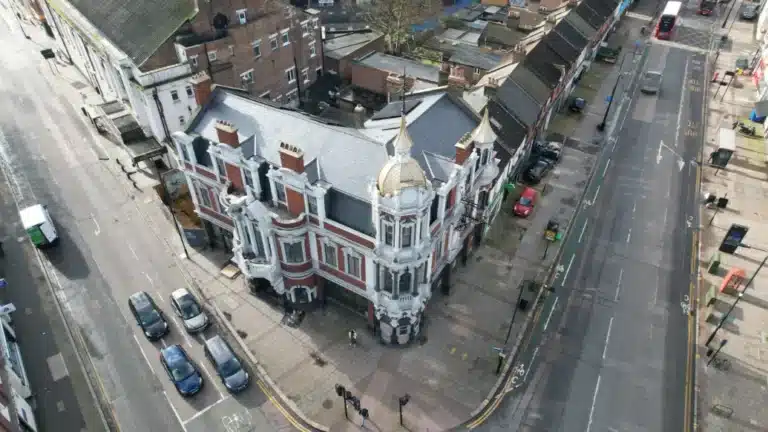 Historic London building with ornate architecture, featuring a prominent dome and intricate detailing, situated at a street intersection, showcasing the blend of urban environment and architectural heritage.