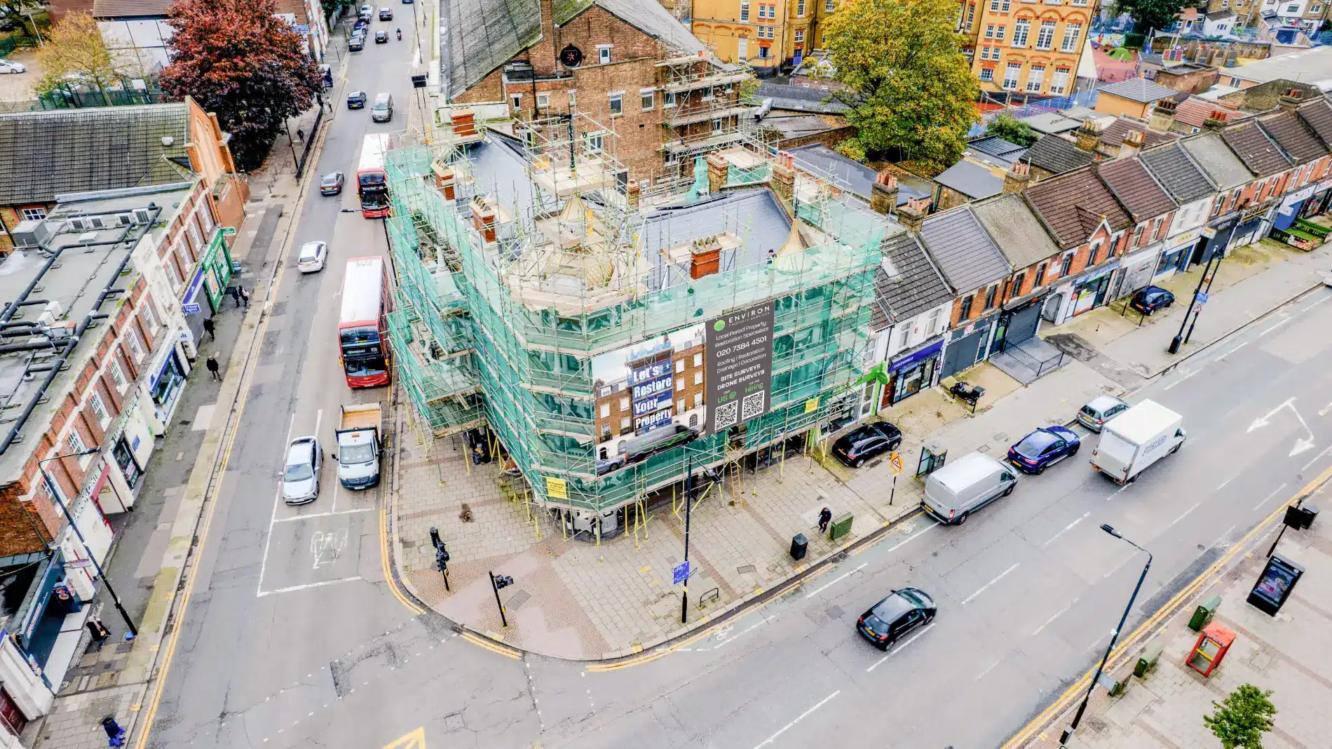 Restoration project by Environ Restoration Services, scaffolding around historic building, London street view with vehicles and pedestrians.