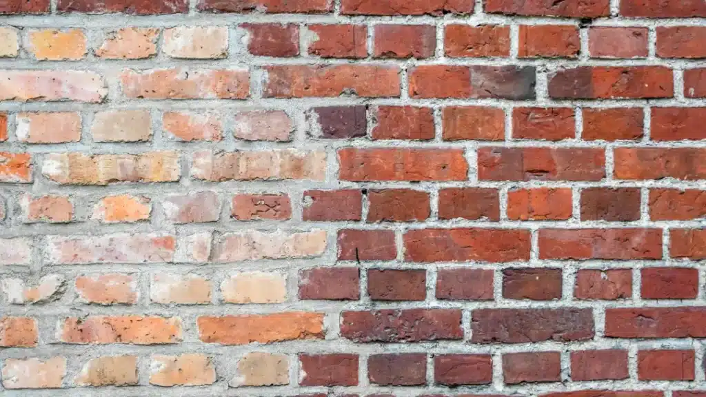 Brick wall showcasing various shades of red and beige bricks, highlighting the importance of regular brick cleaning for maintaining structural integrity and preventing damp.