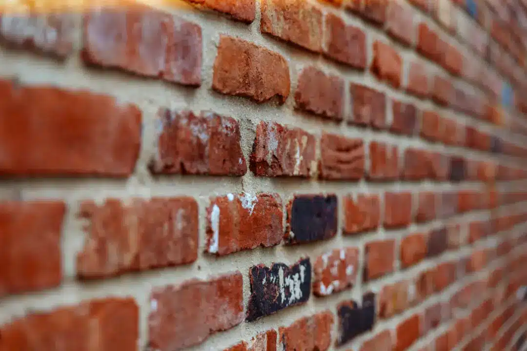 Close-up of a textured brick wall showcasing various shades of red and brown bricks, illustrating the importance of professional brick cleaning for London homes to maintain aesthetic appeal and structural integrity.